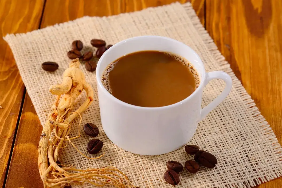 Tazza di caffè con chicchi e radice di ginseng. Alcuni ritengono che il ginseng caffè fa male, ma la ricerca è in corso.