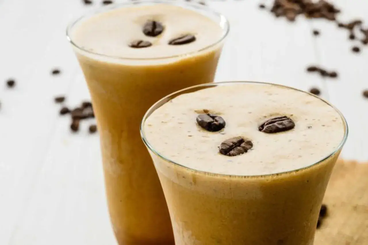 Sorbetto al caffè ricetta: due bicchieri con bevanda cremosa e chicchi di caffè, perfetti per un dessert rinfrescante.