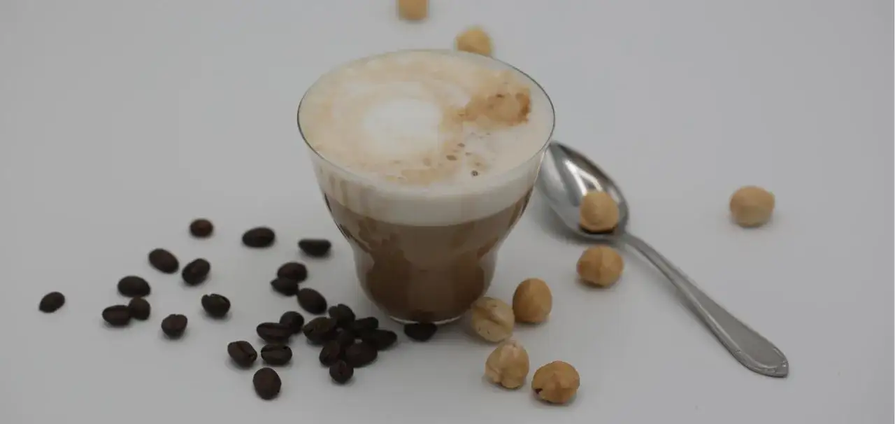 Un delizioso caff&egrave; con Nutella, circondato da chicchi di caff&egrave; e nocciole tostate. Un'esplosione di gusto per iniziare la giornata.