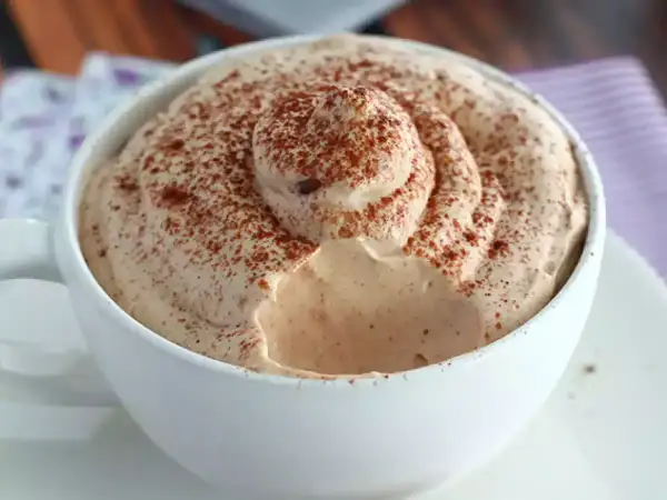Una tazza di caffè con abbondante schiuma cremosa, spolverata di cacao. Un vero piacere per gli amanti del caffè con Nutella.