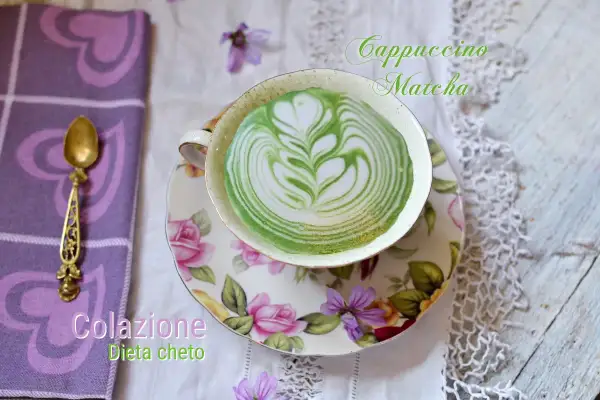 Colazione chetogenica: un cappuccino matcha con latte art verde e bianca, servito in una tazza floreale.