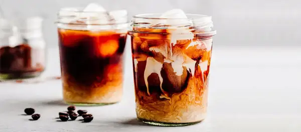 Due bicchieri di iced coffee con ghiaccio e latte che si mescola, un'idea su iced coffee come si fa.