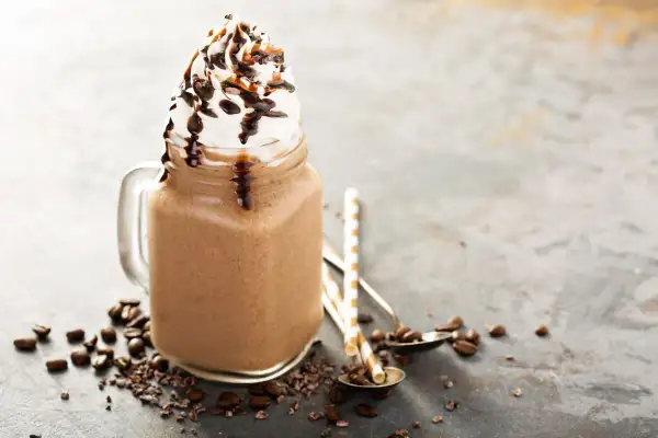 Bevanda fredda al cioccolato con panna montata e sciroppo, ispirata alle ricette Starbucks, con chicchi di caffè e cacao.