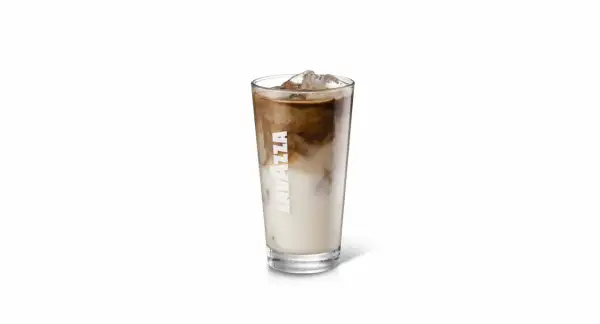 Un bicchiere di iced coffee Lavazza con latte e caffè che si mescolano, pieno di ghiaccio.