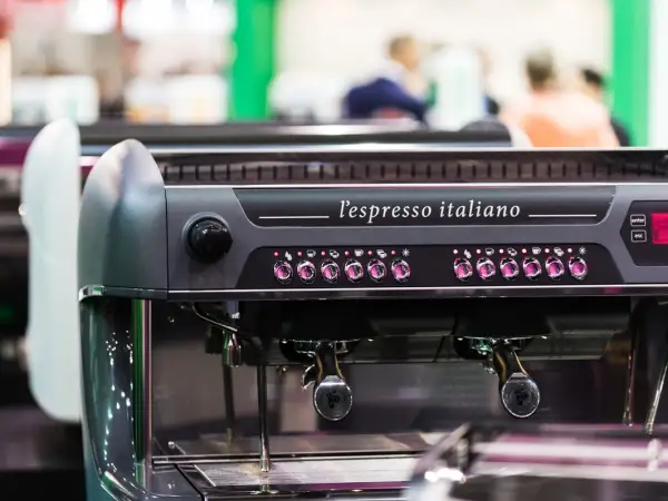 Macchina da caffè professionale, "l'espresso italiano", con pulsanti luminosi e portafiltri pronti per preparare un ottimo caffè.