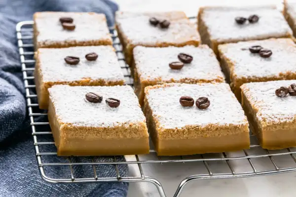Deliziosi dolci al caffè, cosparsi di zucchero a velo e decorati con chicchi di caffè, pronti per essere gustati.