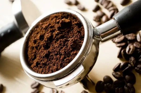 Portafiltro pieno di caffè macinato, pronto per la macchina caffè. Lui ha problemi a preparare un espresso perfetto.
